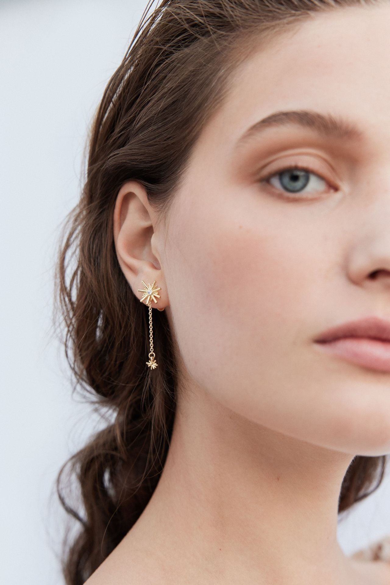 Gold stars and white stone dangling post earrings