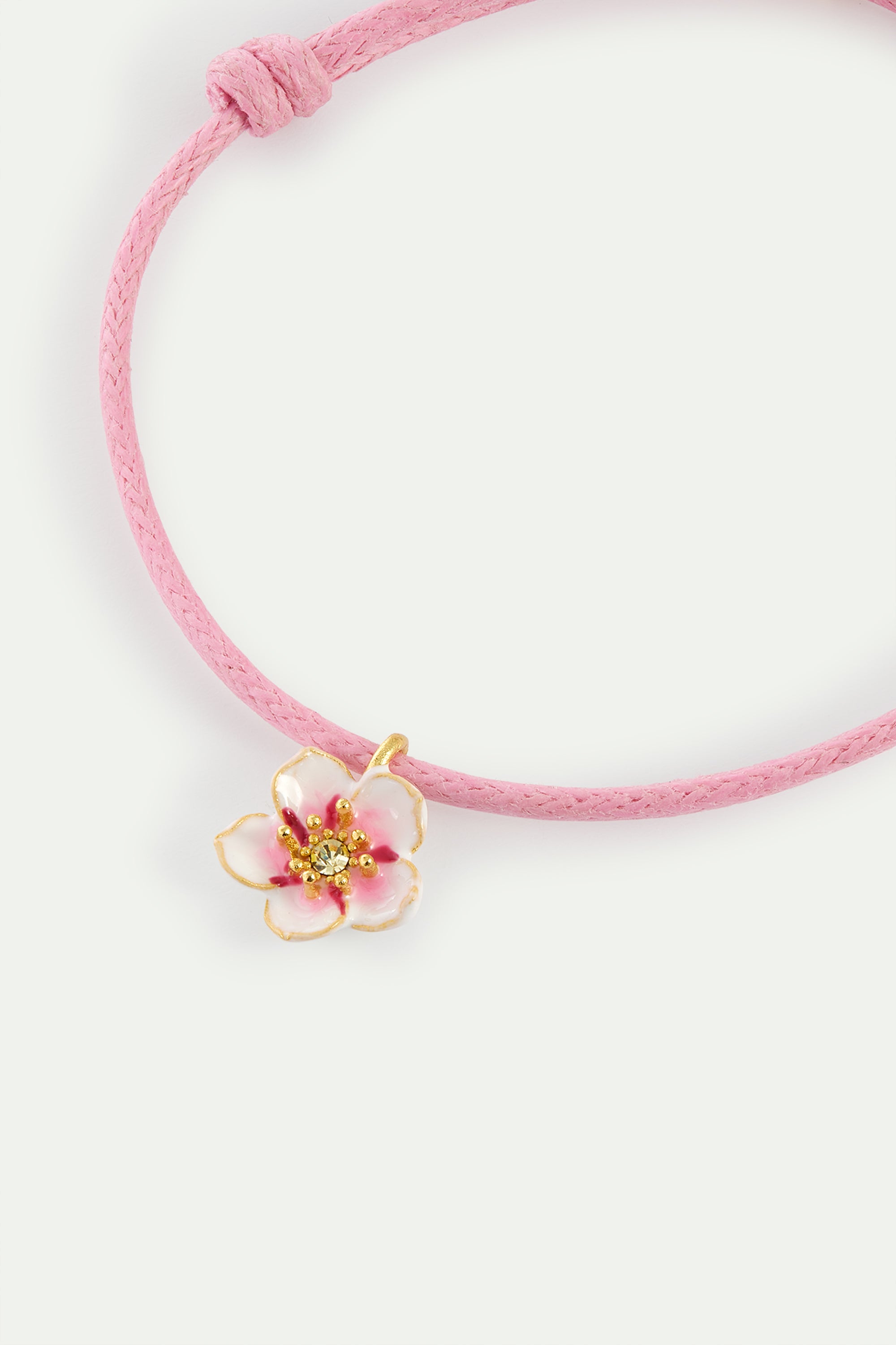 Pink thread bracelet with a tiny white cherry blossom